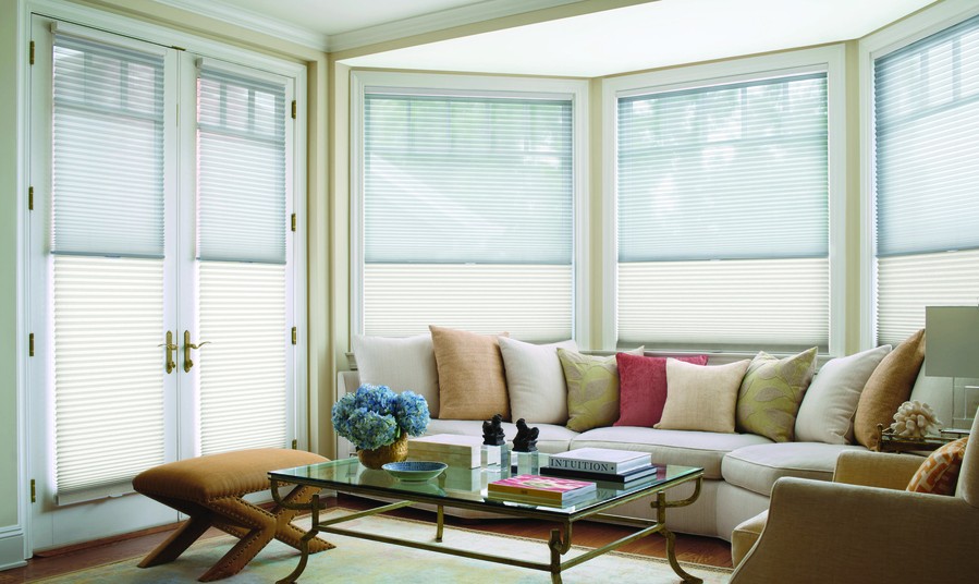 A living room space featuring Hunter Douglas motorized blinds and shades.